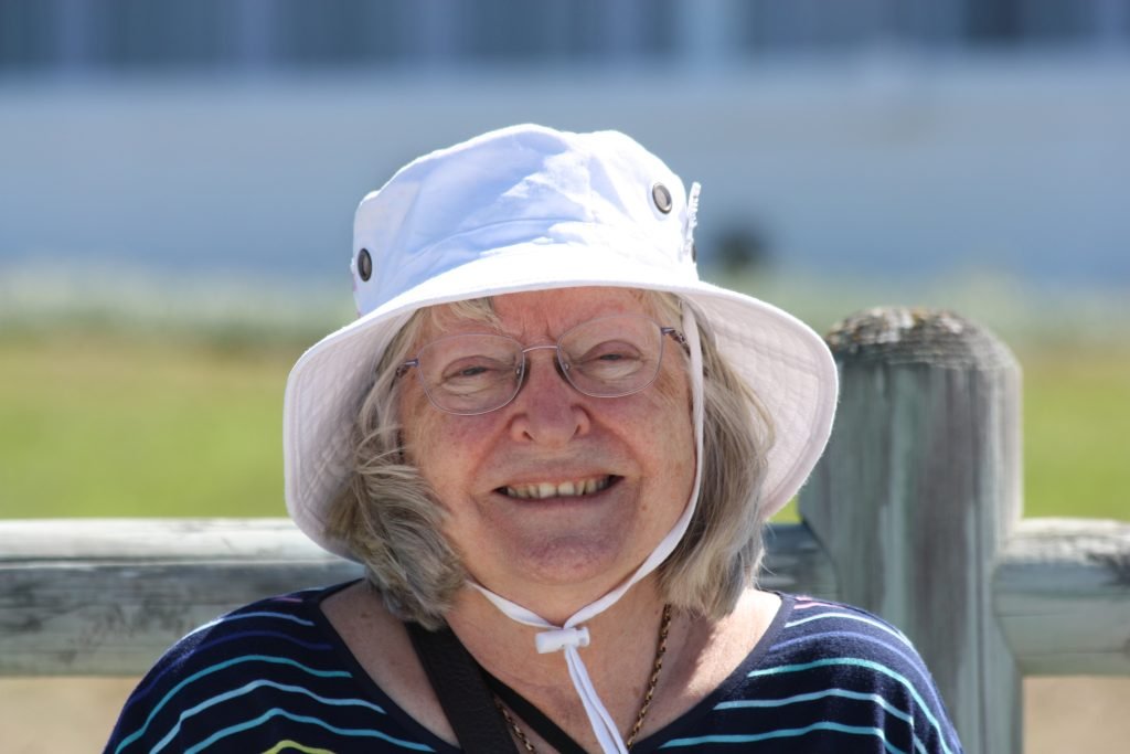 Joan wearing a sun hat, smiling outdoors